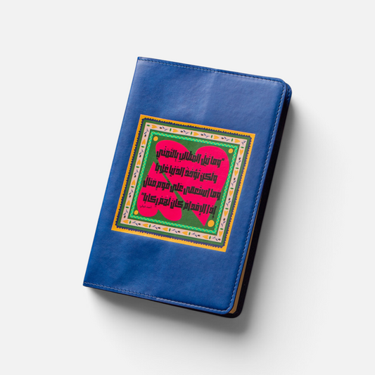 A blue faux-leather notebook cover featuring a colorful Islamic prayer rug (sajadah) design on the front cover, shown on a light gray background with a soft drop shadow.